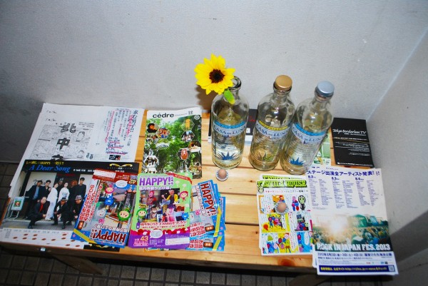 バーボンハウスさんの昇降階段の踊り場にあるテーブルに置かれたハッピー高円寺フライヤー、ボトル
